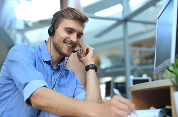 Smiling friendly handsome young male call centre operator. - Powered by Adobe