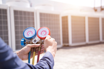 Technician is checking air conditioner ,measuring equipment for filling air conditioners.