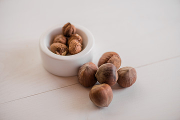 hazelnuts whole kernel on white background with antique nut cracker