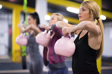 athletes doing exercises with kettlebells