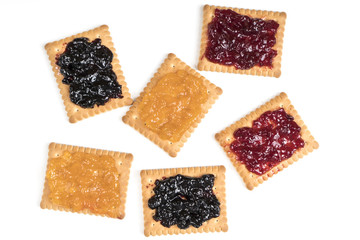 Some dry biscuits with jam on a white surface