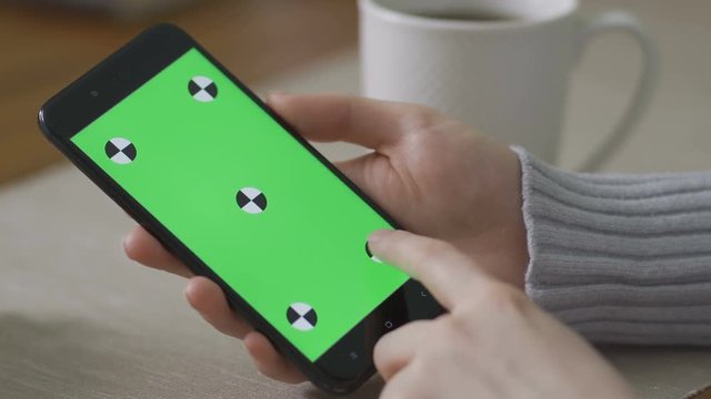 Young Girl is Holding Smartphone with Green Screen at Evening Time.