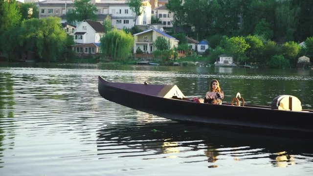 Beautiful brunette posing over beautiful romantic landscape. Traditional Venetian rowing boat