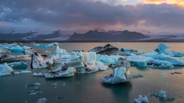 Glaciers in J&ouml;kuls&aacute;rl&oacute;n glacial lagoon water, near Vatnajkull National Park in southeastern Iceland at sunset. Zoom out. 4K UHD timelapse.