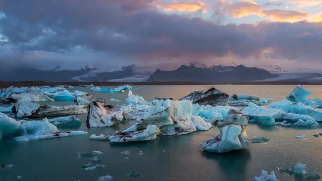 Glaciers in J&ouml;kuls&aacute;rl&oacute;n glacial lagoon water, near Vatnajkull National Park in southeastern Iceland at sunset. Zoom out. 4K UHD timelapse.
