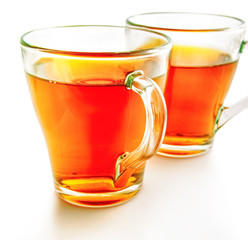 Two glass cups of tea on a white background