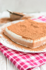 Homemade layered cottage cheese souffle dessert with cocoa on white wooden table