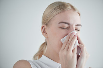Rhinitis. Girl with napkin on white background