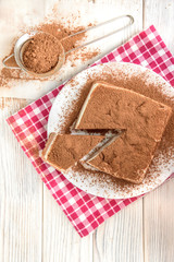 Homemade layered cottage cheese souffle dessert with cocoa on white wooden table