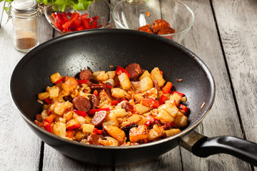 Tortilla de patatas. Cooking spanish omelette with sausage chorizo, potatoes, paprika in the pan