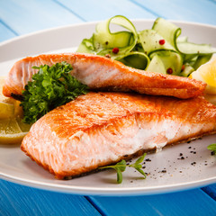 Grilled salmon with vegetables on blue wooden table