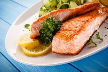 Grilled salmon with vegetables on blue wooden table