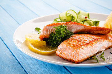 Grilled salmon with vegetables on blue wooden table
