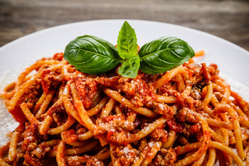 Pasta with meat and tomato sauce on wooden table