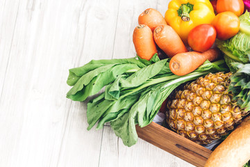 Top view of different fresh fruits and vegetables on the white wooden table with copy space.Healthy eating