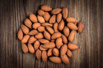 Almond on dark wooden background. Healthy snack.