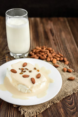 Cottage cheese with yogurt and almonds on dark wooden background. Healthy food.