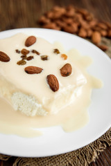 Cottage cheese with yogurt and almonds on dark wooden background. Healthy food.