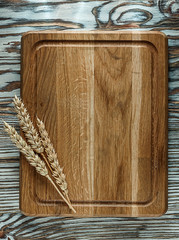 Chopping board wheat ears on vintage wooden surface