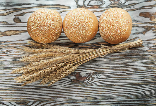 Crusty bread bunch of wheat ears on vintage wooden surface
