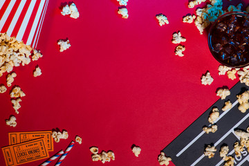 Movie tickets, clapperboard, pop corn on red background