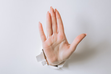 Naklejka premium girl hand breaks white paper and shows a gesture