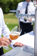 waiter pouring draft beer into a glass
