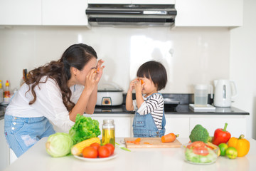 Mother with her daughter in the kitchen cooking together
