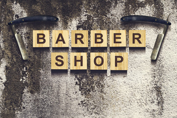 Concept Barber Shop. An inscription on wooden cubes against the background of an old vintage wall.