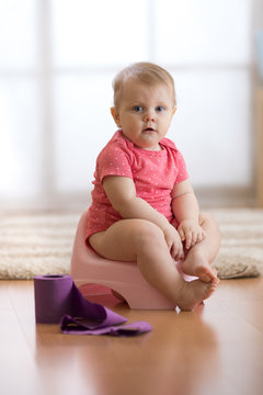 Funny Baby Girl Sitting On Chamberpot In Room