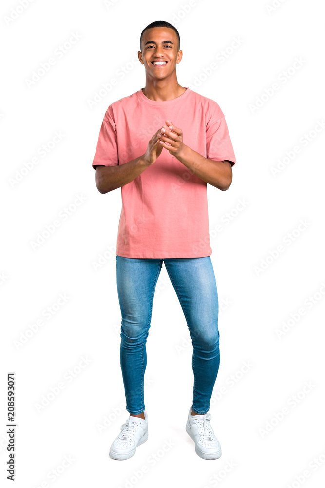 Wall mural Standing young african american man smiling and applauding on isolated white background