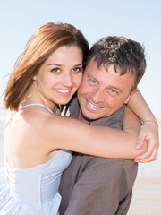 young happy smile couple in love play on sand beach summer vacation day