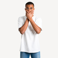 Fototapeta premium Young african american man covering mouth with both hands for saying something inappropriate. Can not speak on isolated background