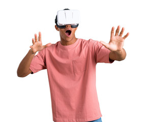 Young african american man using VR glasses. Virtual reality experience on isolated white background