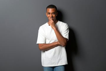 Young african american man on grey wall background thinking