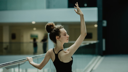 Young slim and beautiful ballerina practicing ballet positionon on the dancing hall.