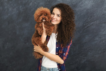 Studio shot of happy woman with cute curly dog