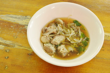 braised pork and bean sprout in brown soup on bowl