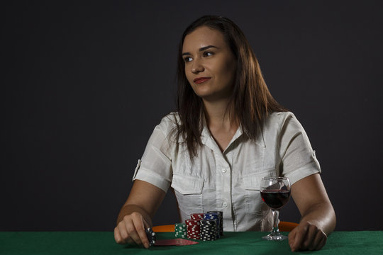 Young girl with a glass of wine playing poker