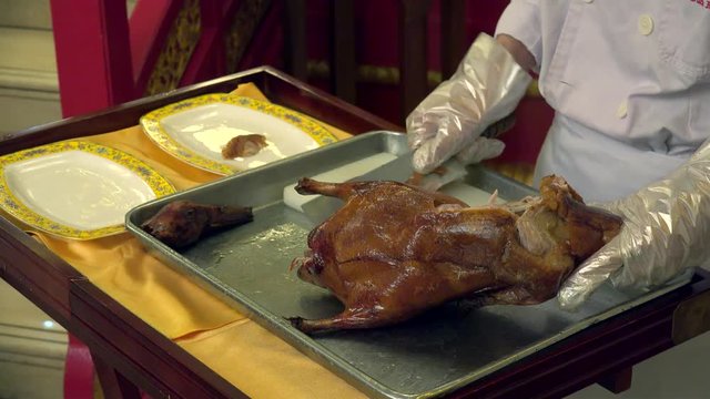 Chef of China restaurant is slicing roasted Peking Duck. Beijing, China.