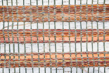 The texture of the surface of the braided birch bark with colored ropes, beautiful handmade pattern...