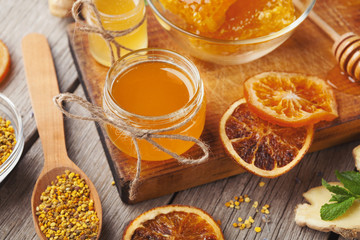 Various types of honey on wooden platter, closeup