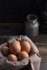 Chicken eggs in a tray with a brown cloth.on old black stained wooden table / Selective focus