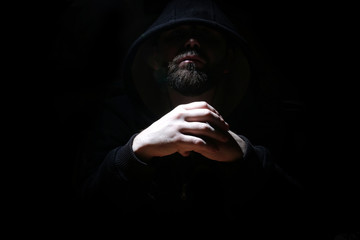 Man in a black hood and smoke