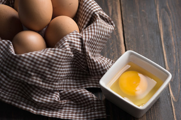 Chicken eggs in a tray with a brown cloth.on old black stained wooden table / Selective focus