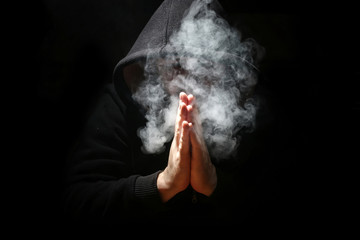 Man in a black hood and smoke