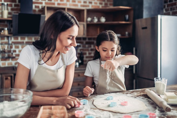 Fototapeta na wymiar mother and daughter preparing dough for cookies