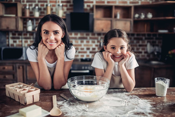 daughter and mother with noses in flour