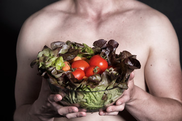 Man and salad. Healthy lifestyle. Black background.