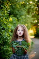 Naklejka premium Baby 4 years, with blue eyes, small curls. A wonderful time of childhood and adventure. Warm sunlight Derita in the hands of the leaky mug.
